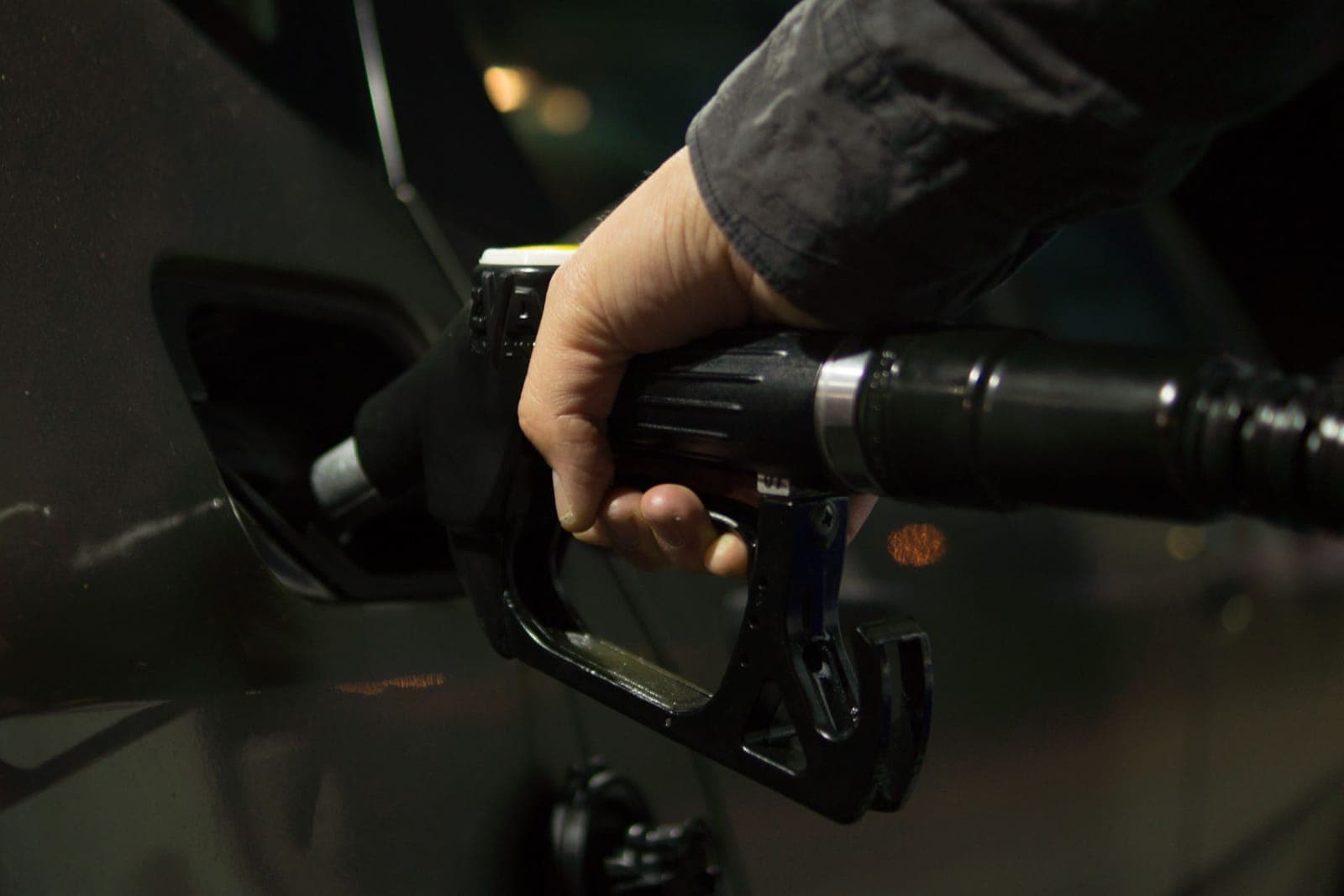 Main tenant un pistolet de carburant pendant un plein